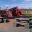 Parco giochi con il castello Mastodon con set di scivoli, inclusi due scivoli rossi e struttura da arrampicata