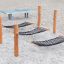 Attrezzatura da parco giochi Hammock con pali in legno e rete nera su superficie sabbiosa