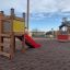 Toddler Tower Slide in legno con scivolo rosso nel parco giochi.