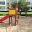 Toddler Tower Slide con scivolo rosso e pannello giallo in un parco giochi.