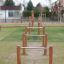 Attrezzatura da gioco all'aperto Single Somersault Nature con pali di legno e barre metalliche.
