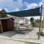 Sun Shade Square Pioneer (Larchwood) che fornisce ombra sopra i tavoli da picnic in un'area all'aperto.
