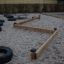 Classic Nature Trim Trail in un'area giochi sabbiosa con travi di equilibrio in legno e ostacoli da arrampicata con pneumatici