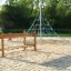 Bambini che giocano su Classic Nature Trim Trail in un'area giochi con piramide da arrampicata con corde.