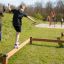 Bambini che giocano sulle travi di equilibrio Classic Nature Trim Trail in un parco.