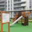 Set di attrezzature per parco giochi chiamato Rules Tab con scivolo, rete da arrampicata e altalena.