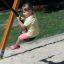 Bambino che dondola su un'altalena di corda nel parco giochi.