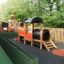 Locomotive with slide train playhouse in un'area giochi recintata.
