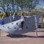 Bambini che giocano su Aztec play loop steel structure in un parco giochi.