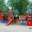 Attrezzatura colorata da area giochi Bounty ship with slide su un'area sabbiosa circondata da alberi