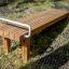 Gymnastic bench realizzato con listelli di legno e una maniglia in metallo in un ambiente esterno.