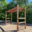 Scala da parco giochi in legno per esterni con barre orizzontali e gradini per arrampicata.