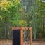 Casetta da gioco in legno con parete da arrampicata in un parco giochi nel bosco.