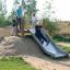 Bambini che giocano su Hill Slide Wide h150 in un parco all'aperto.