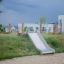 Scivolo Hill Slide Wide h120 per parco giochi all'aperto su una collina erbosa.