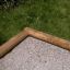 Angolo in legno di 5-angle palisade sandbox sull'erba.