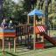 Bambini che giocano sul Jubilee Unit castle with slide in un parco.