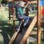 Bambino che gioca sul Jubilee Unit castle with slide in un parco.