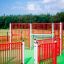 Sistema di recinzione con cancello rosso e bianco su un'area giochi verde Allianz Arena.
