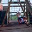Bambino che si diverte sul Swing Frame (double swing) nel parco giochi