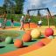 Bambini che giocano su Swing Frame (double swing) in un parco giochi colorato.