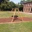 Swing Frame (single swing, wide) in un'area giochi erbosa con base in cippato di legno
