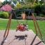 Tre bambini che giocano su un Swing Frame (single swing, wide) in un parco.