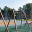 Swing seat: Safety seat in un parco giochi con struttura da arrampicata e altre attrezzature da gioco sullo sfondo