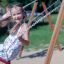 Bambino che gioca su un seggiolino a dondolo: seggiolino di sicurezza nel parco giochi