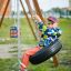 Bambino che dondola su un'altalena Tire seat nel parco giochi.