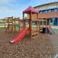 Lemur single slide in un parco giochi con struttura in legno e tetto rosso