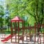 Struttura da gioco in legno con scivolo rosso Lemur single slide in un parco
