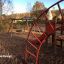Panther wooden playhouse in un parco giochi con altalene e strutture da arrampicata sullo sfondo