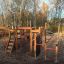Panther wooden playhouse con scivoli e strutture da arrampicata in un parco giochi