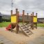 Parco giochi per bambini Mini play con scivolo, scale e base di sabbia in un parco all'aperto.