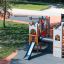 Attrezzatura da parco giochi Camelot castle with slide in un parco con funzioni di arrampicata e scivolata