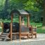 Locomotive Nature train playhouse in un parco giochi con un bambino che gioca all'interno.