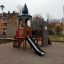 Tintagel playground castle con scivolo e struttura da arrampicata in un parco giochi di un'area residenziale.'