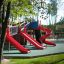 Slide rosso in un parco giochi con più Slide e strutture da arrampicata