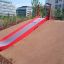 Slide rosso installato su una collina del parco giochi.