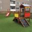 Hill Slide SL90 con uno scivolo rosso e una casetta in legno in un parco giochi
