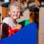 Bambino che gioca su attrezzatura da parco giochi Pi con un volante rosso.
