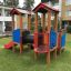 Smart playhouse with slide in un ambiente di parco giochi.