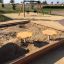 Sabbiere per bambini con sedili gialli in un parco giochi.