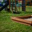 Sandpit in legno in un parco giochi con scivolo e struttura da arrampicata