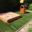 Sandpit in legno con casetta da gioco in un parco giochi da giardino.