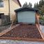 Sabbiere in legno con altalene da gioco in un giardino.