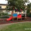 Parco giochi per bambini Sandpit a forma di treno con scivolo in un parco.