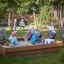 Bambini che giocano in un Sandpit in un parco giochi.
