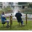Due persone anziane che utilizzano l'attrezzatura per esercizi Training twist & sit in un parco vicino a una fontana.